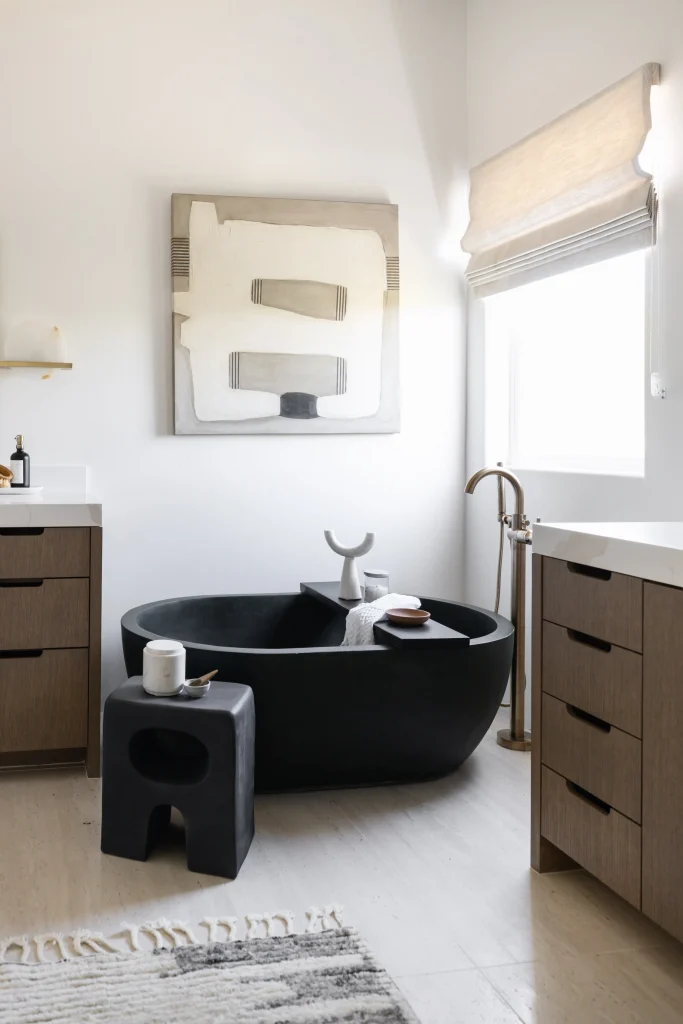 Luxury bathroom with black freestanding tub and wood cabinets