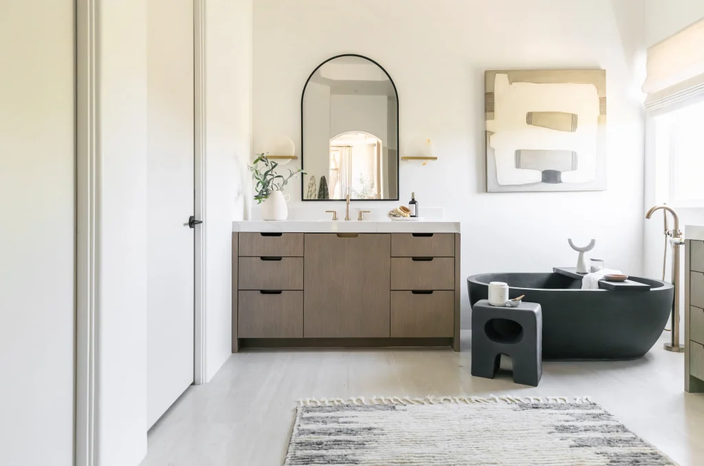 Modern bathroom with black freestanding tub and wood cabinetry