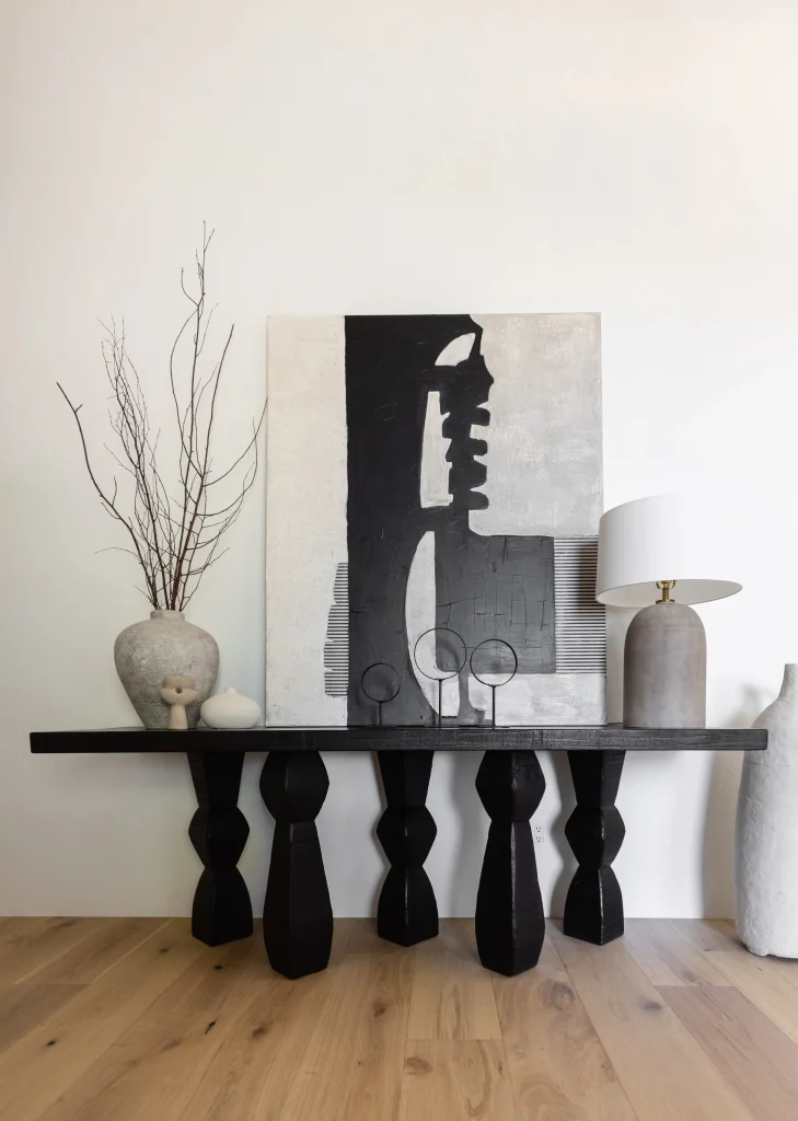 Abstract black and white art on console table with vases