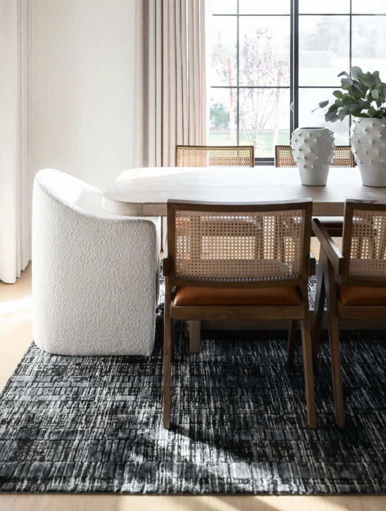 Dining table with cane chairs and white armchair