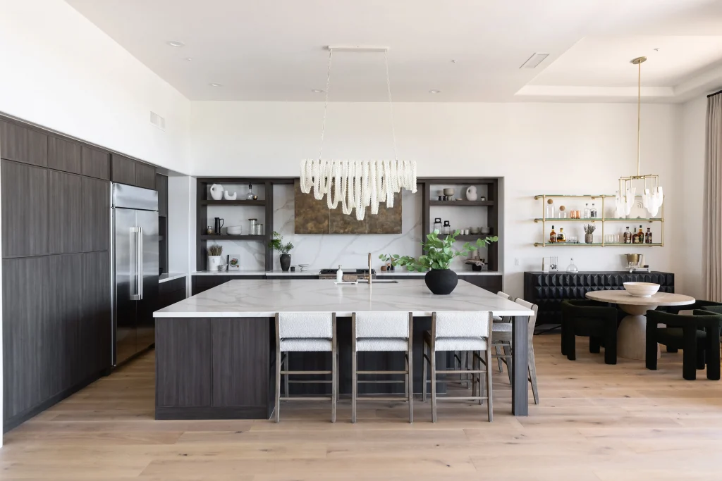 Open-concept kitchen and dining area with marble island and elegant chandelier