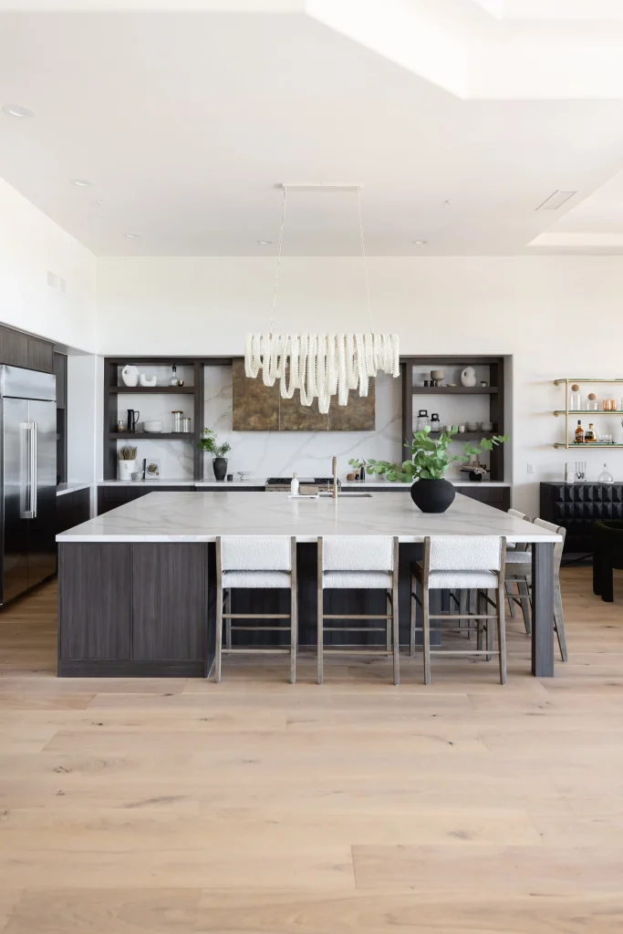 Open kitchen with marble island and dark cabinetry