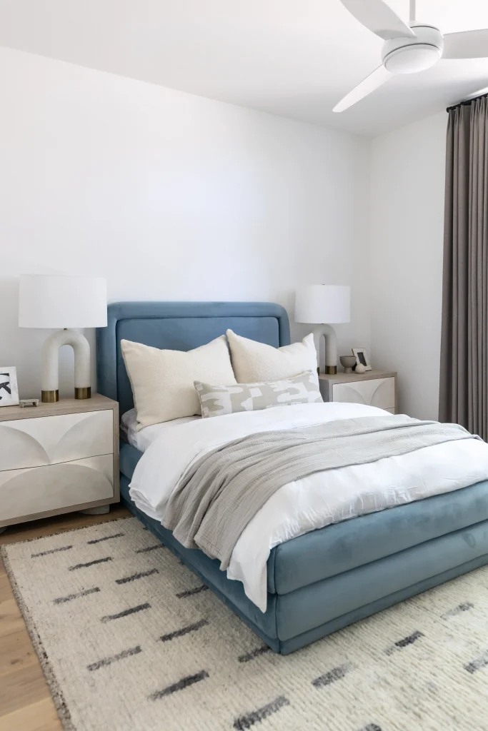 Cozy bedroom with blue upholstered bed and neutral bedding