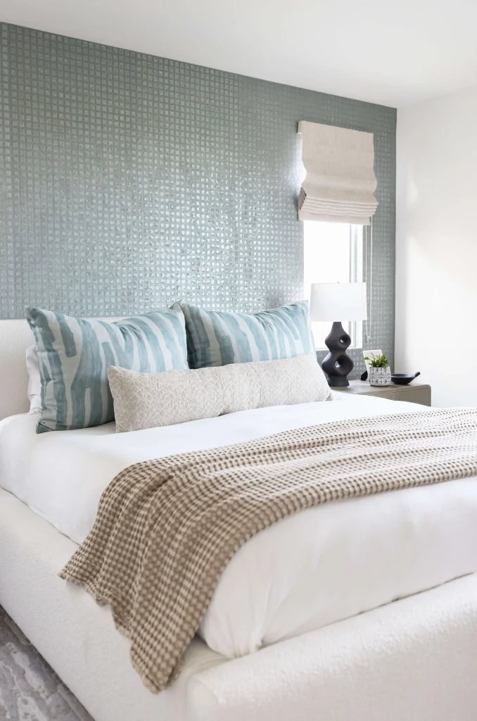 Cozy bed with blue pillows and textured wall