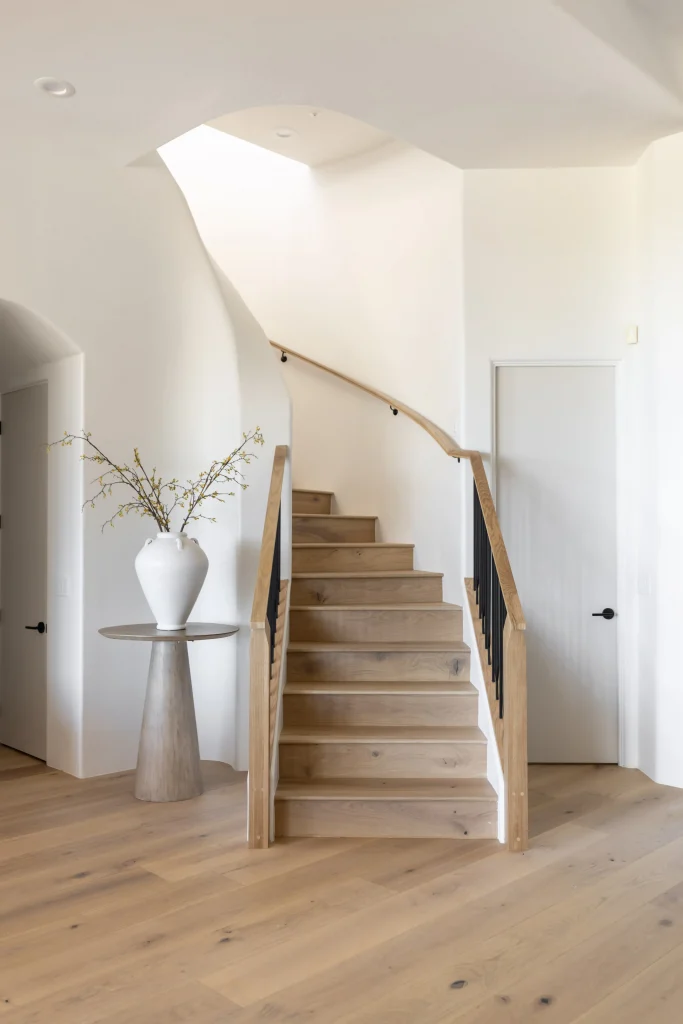 Staircase with wooden handrail and sculptural vase
