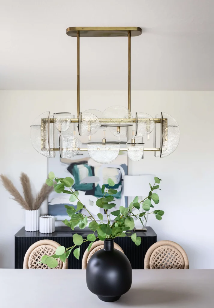 Modern chandelier above dining table with vase