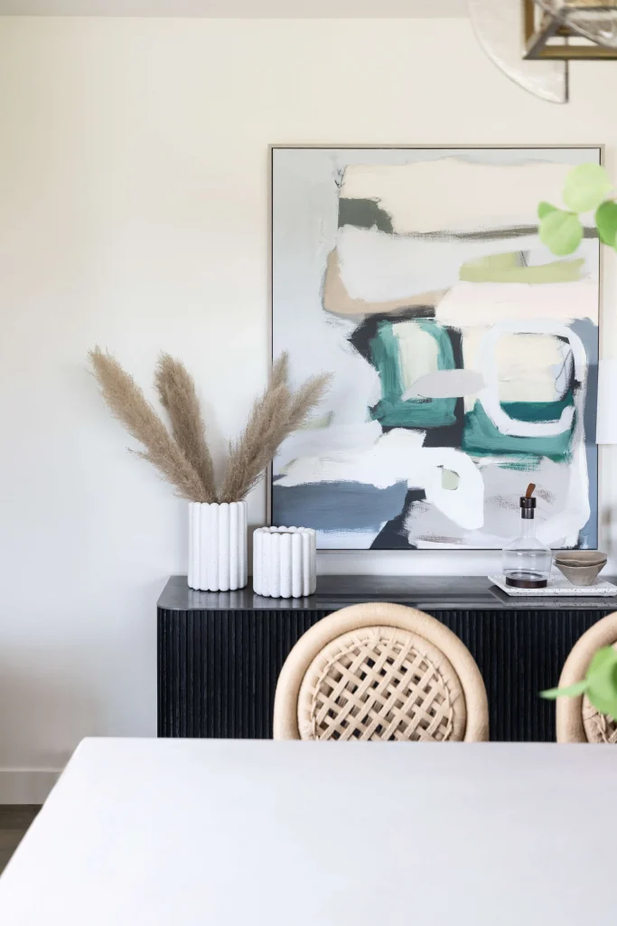 Dining area with abstract art and wicker chairs