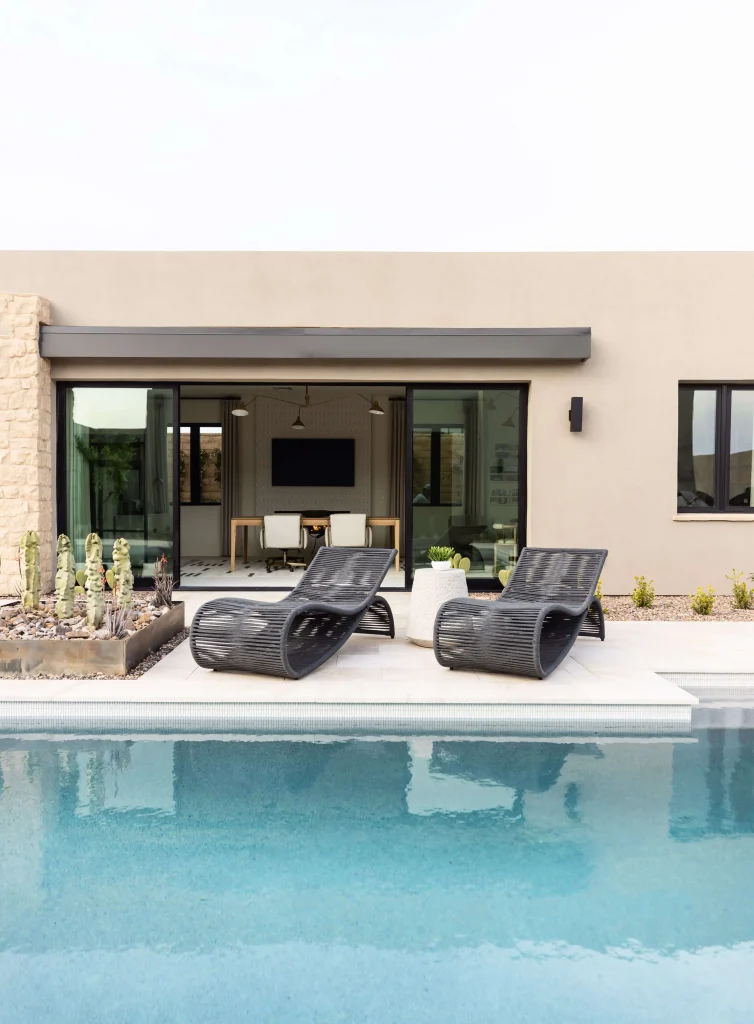 Modern backyard with pool and black lounge chairs