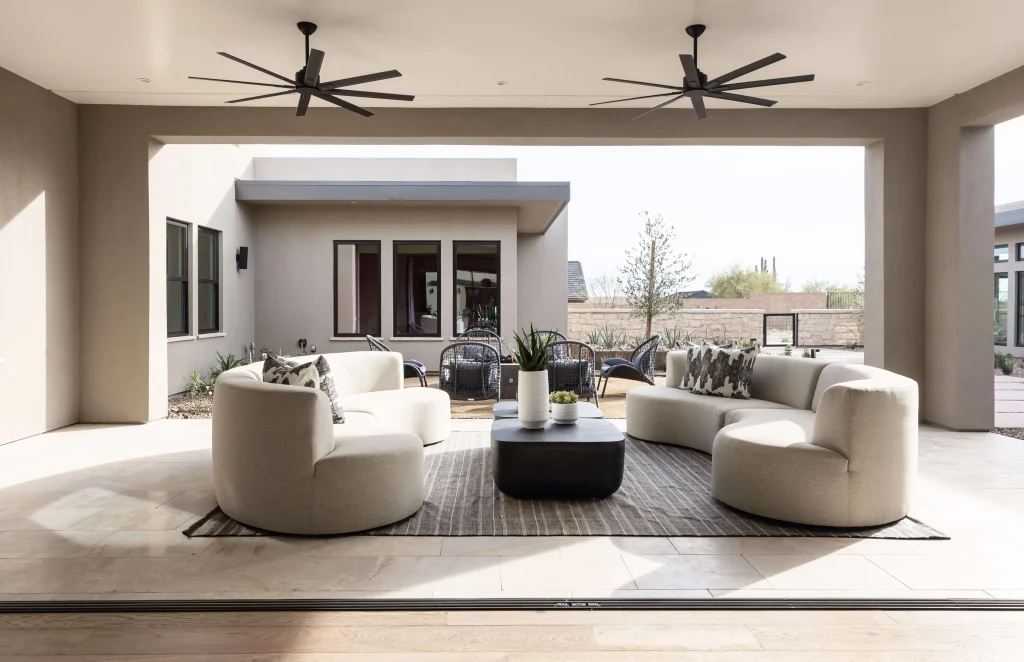 Covered patio with modern lounge chairs and ceiling fans