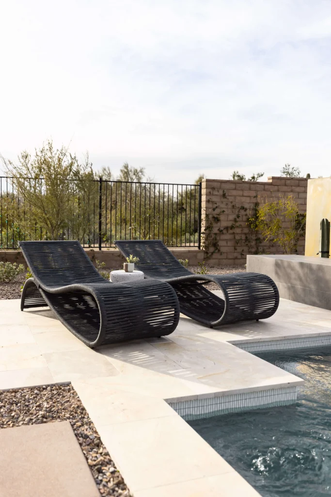 Black woven lounge chairs by a modern pool