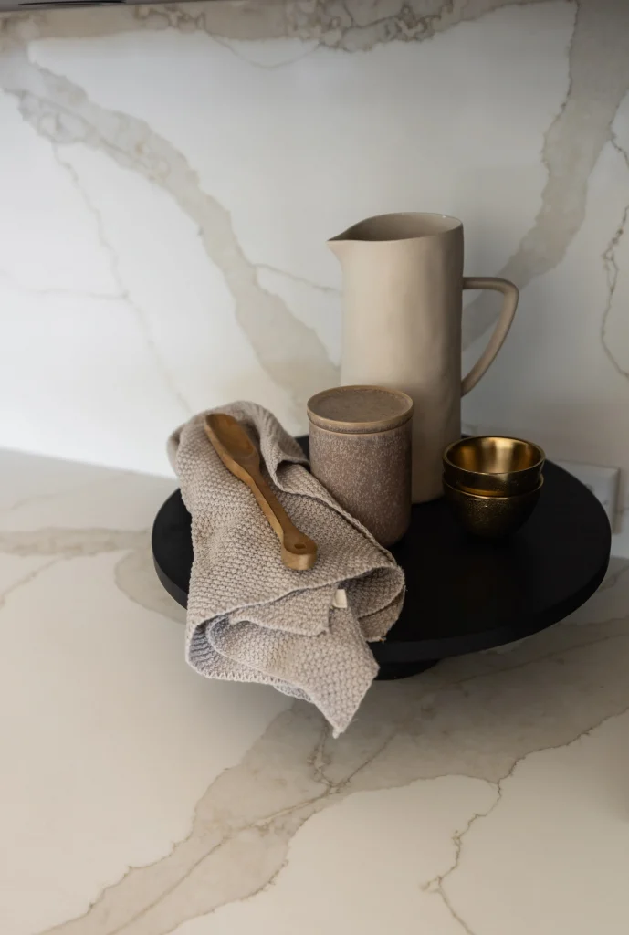 Styled vignette of ceramic tabletop decor with gold spoon and beige napkin