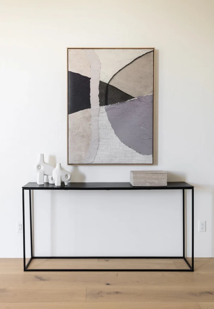 Minimalist entryway console with abstract wall art and sculptural objects