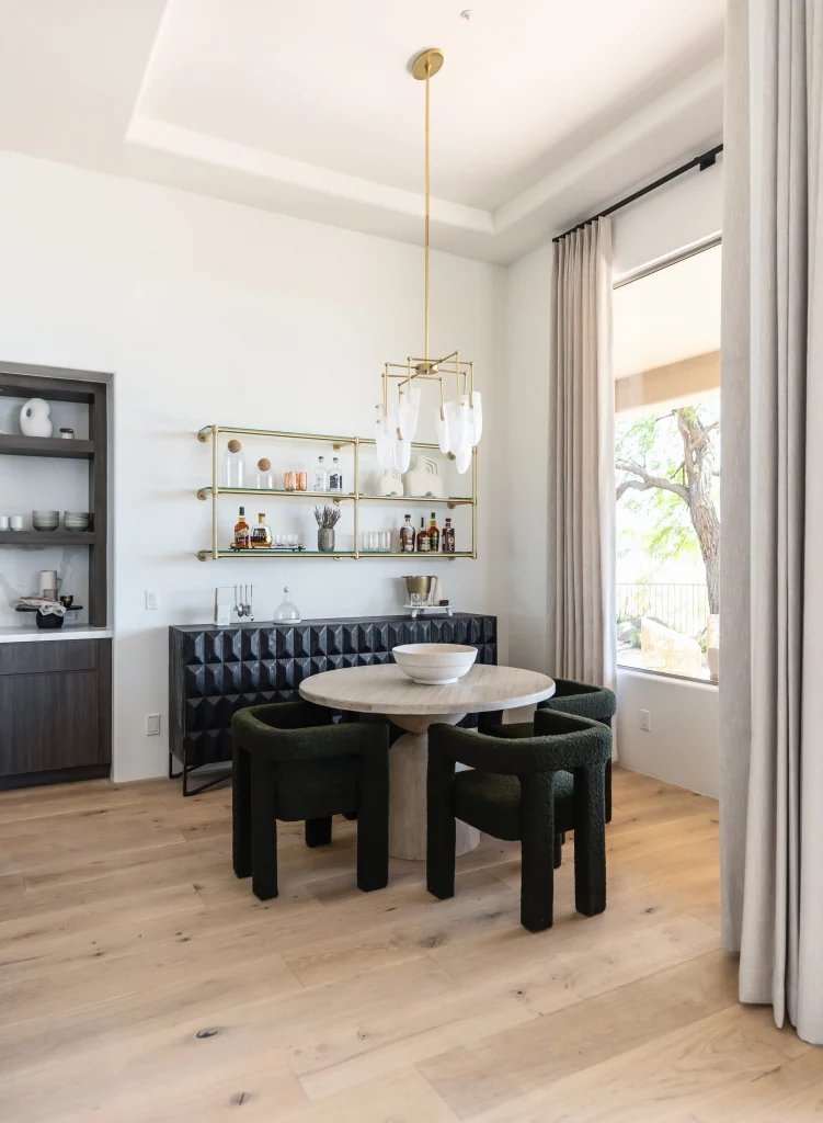 Breakfast nook with black leather banquette and gold bar shelves