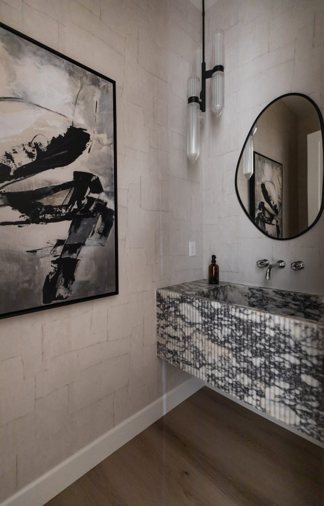 Marble sink and abstract art in modern bathroom