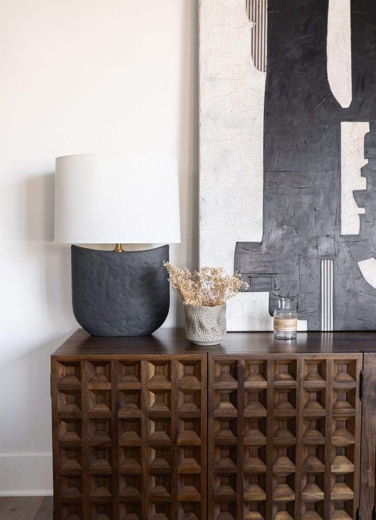 Dark wood cabinet with lamp and modern decor