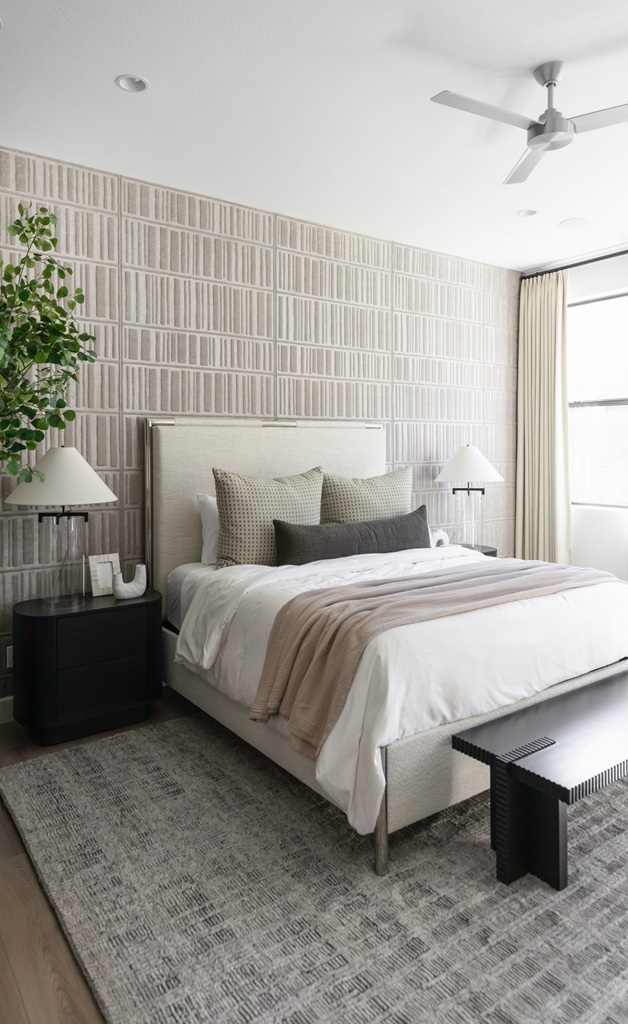 Modern neutral bedroom with textured wall and cozy bedding