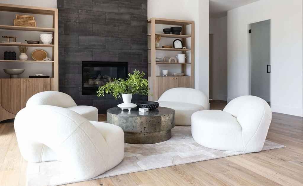 Cozy modern living room with white chairs and stone fireplace