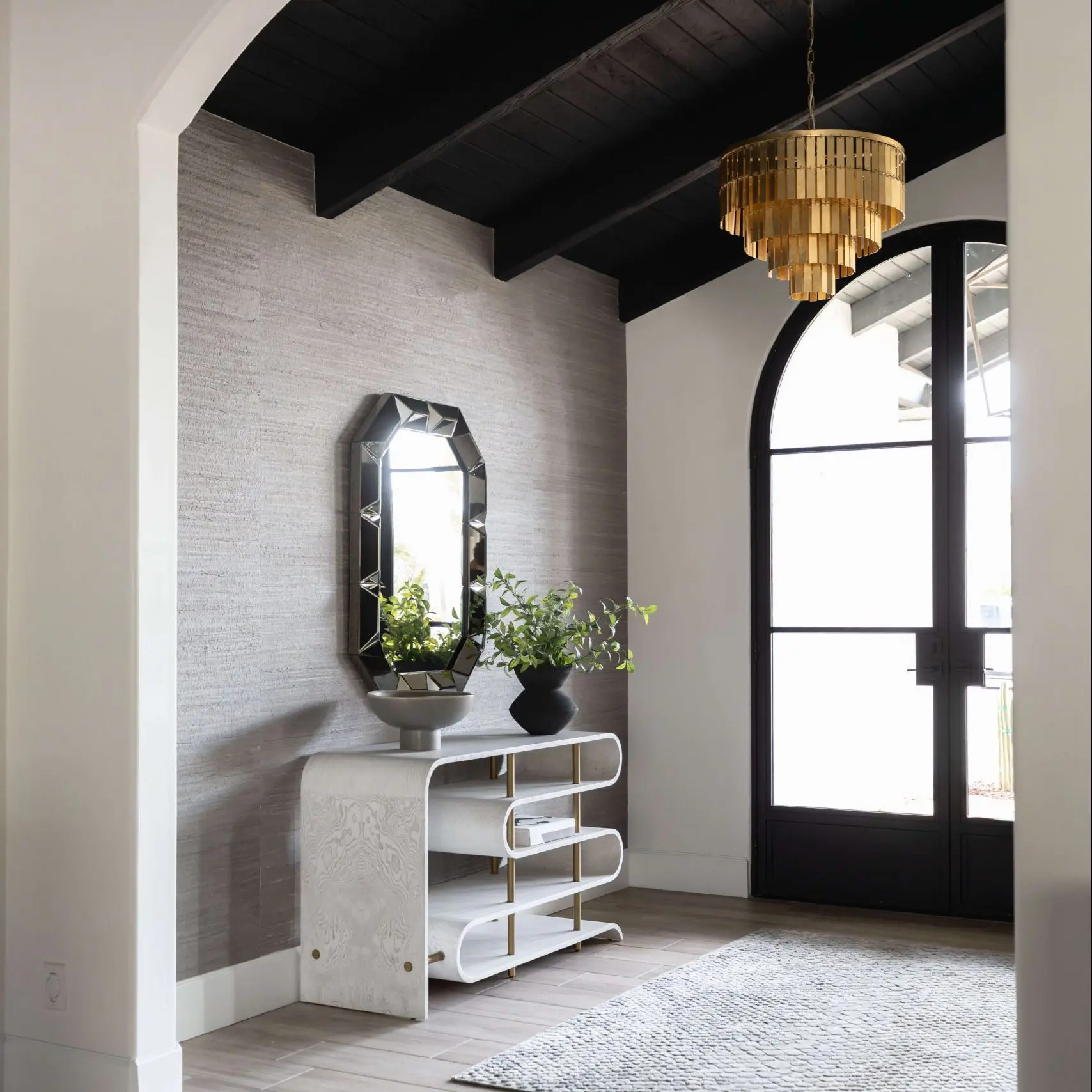 Entryway with arched door and gold chandelier