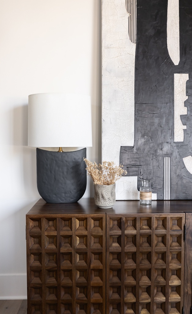 Black lamp and dried flowers on wood sideboard