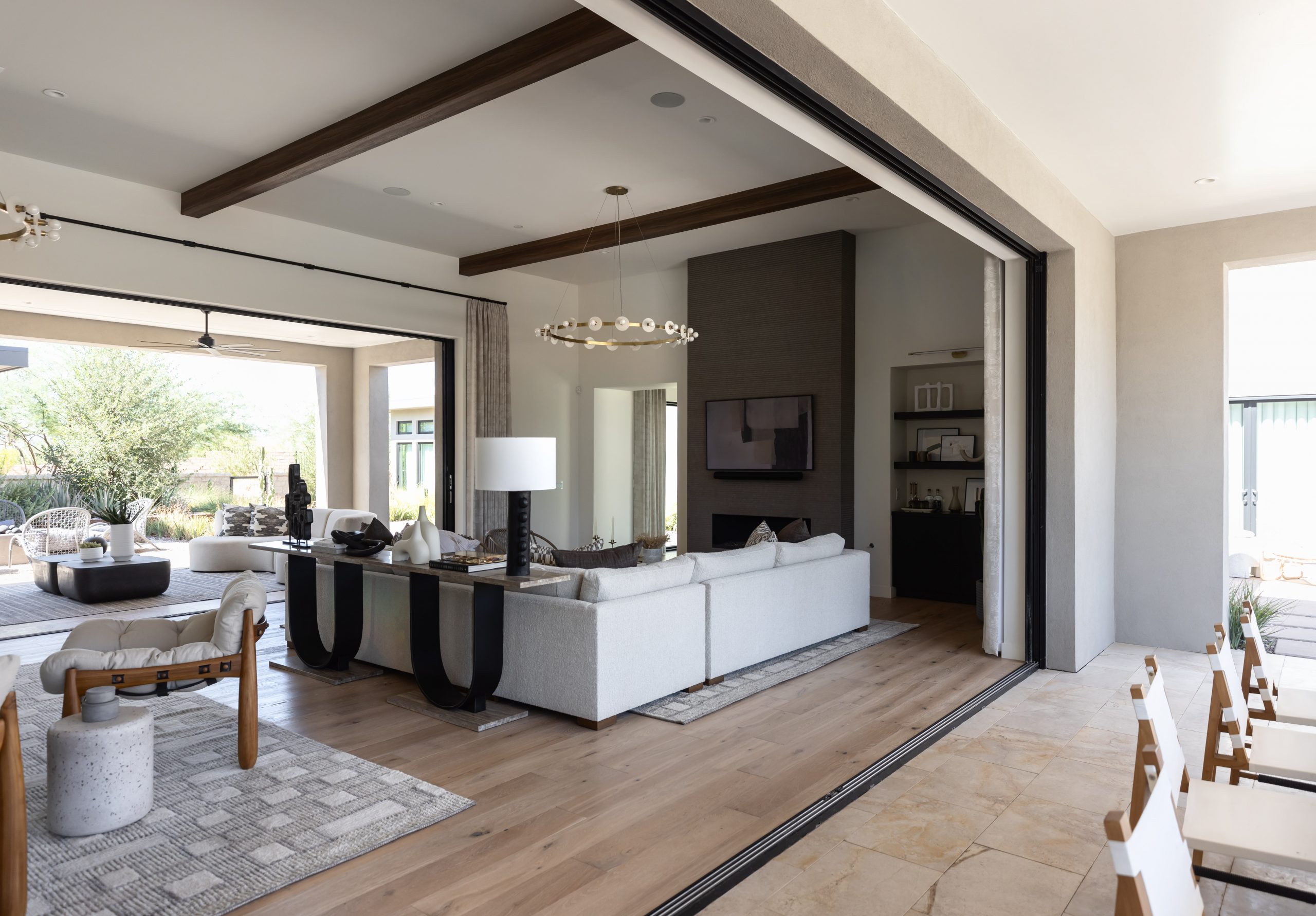 Open-concept living room with light wood floors, a large sectional sofa, wall-mounted TV, and sliding glass doors to a patio—Living with Lolo. Open-concept living room with light wood floors, a large sectional sofa, wall-mounted TV, and sliding glass doors to a patio—Living with Lolo.