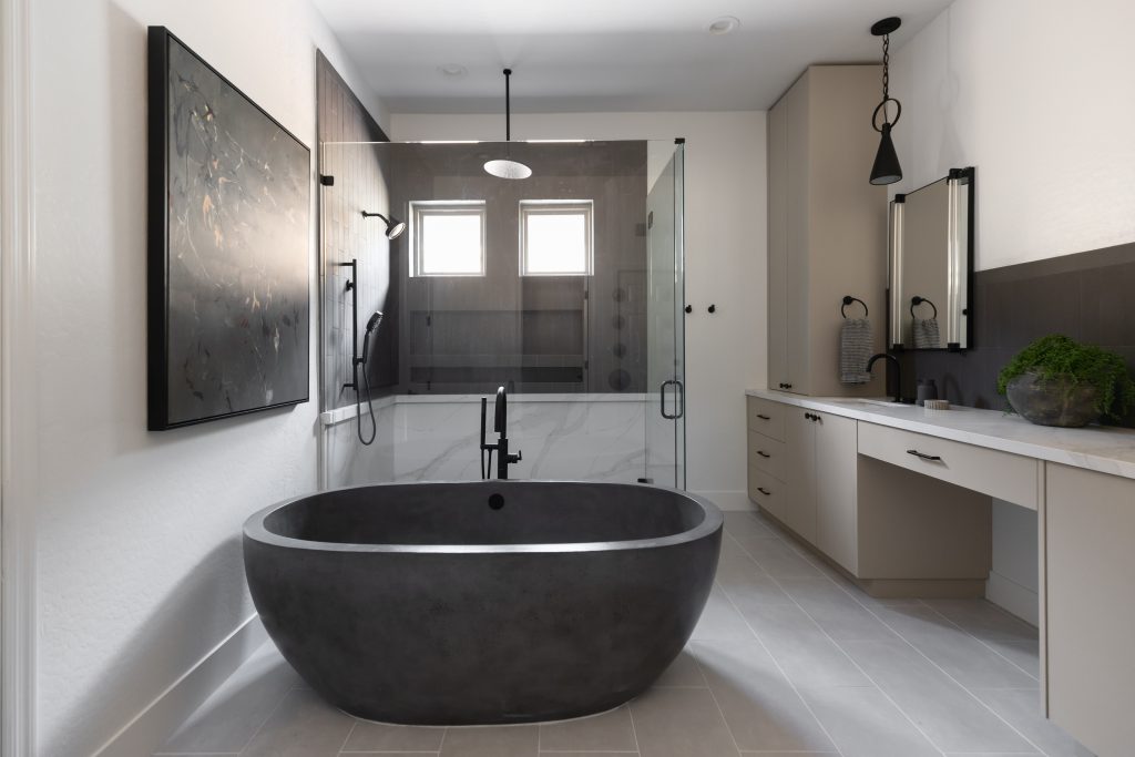 Modern bathroom featuring a freestanding black bathtub, glass shower enclosure, vanity with sink and mirror, and neutral tones — Living with Lolo.