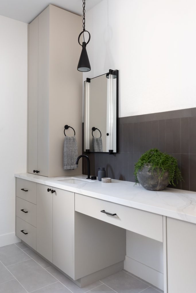Modern bathroom with light gray cabinets, black fixtures, a rectangular mirror, and white marble countertop—Living with Lolo.